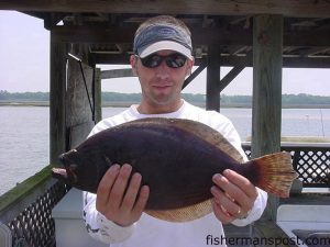 Zane Franks, from Cary, N.C., with a flounder he hooked on a live mud minnow while fishing the ICW near Holden Beach with Paul Dunwell.