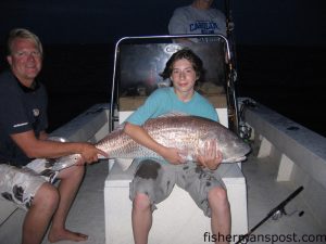 Capt. Buddy Goodwin, of Goodwin's Guide Service, and Phil Averitt, from Greensboro, with a 55" bull red drum that fell for a chunk of mullet near Cedar Island.