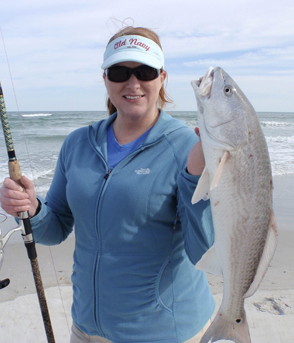 Cindy Smith, of Raleigh, NC, with an overslot red drum she hooked on cut mullet in the Topsail surf. The fish was released after the photo.