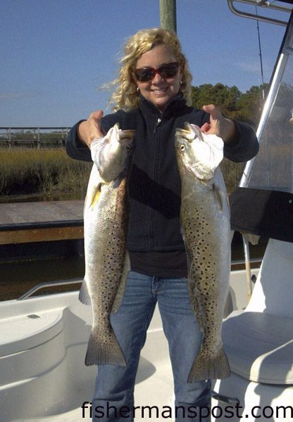 Lindsay Farris with 4.5 and 5 lb. speckled trout she hooked on live shrimp in Wildlife Creek while fishing with Adam Spiliotis of Southport Marina.