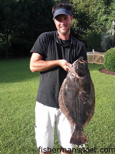 Jeremy Burnett, of Wilmington, with a 9 lb., 29″ flounder that bit a live menhaden at an ICW dock in Masonboro Sound.