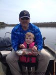 Luke Tierney (age 2) and his grandfather James Demyan with Luke's first fish, a speckled trout he caught and released after it bit a mud minnow in the backwaters near Oak Island.