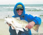 Betty Wright, of TW's Tackle, with a puppy drum she hooked on cut shrimp near Oregon Inlet while fishing with her daughter and son-in-law.