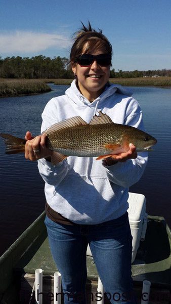 Carrie Lucht with her first red drum, a 20″ fish that bit a D.O.A. paddletail soft plastic while she was fishing in Queens Creek with Marcus Denning.