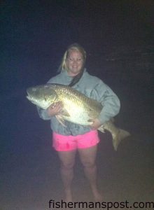 Heather Shaw, of Hatteras Island, with a 49" red drum she caught and released in the surf at Cape Point after it fell for a chunk of menhaden.