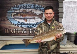 David Lindley, of Newport, NC, with an upper-slot red drum he hooked on a cut bait in the surf at Fort Macon. Photo courtesy of Chasin' Tails Outdoors.