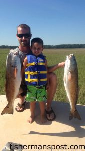 Ben and Kaden Milliken with a pair of slot red drum that bit live mud minnows near Southport.