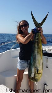 Nicole St. Cyr, of Southport, with a 26 lb. dolphin she hooked while trolling 60 miles off Bald Head Island with Patrick Jones and Andy and Boyce Broadwell on the "Nauti Lady."