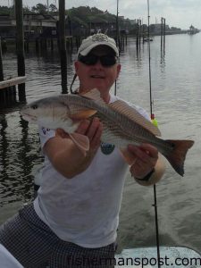 Dr. Robert Littleton with a red drum that bit a live mud minnow near a Holden Beach dock.