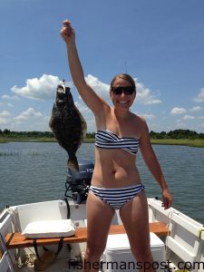 Lauren Robbins, of Raleigh, with a flounder that struck a white soft plastic bait in a Topsail Beach creek while she was fishing with Seavy Dickson on the "Dramamine Dragon."