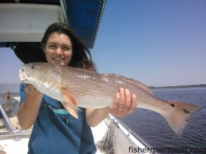 Mallory Ables, of Charlotte, NC, with a red drum that bit a live bait near Oak Island while she was fishing with Capt. Greer Hughes of Cool Runnings Charters.