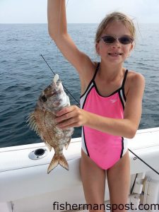 Baylor Tietjen with her first fish, a whitebone porgy that bit squid near the Liberty Ship while she was fishing with her dad on the "Double Trouble."