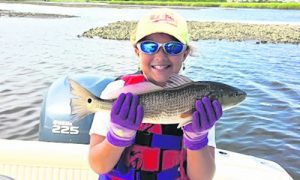 Paige Lisson (age 9) with a red drum that struck a live mud minnow in Davis Creek while she was fishing with her father.