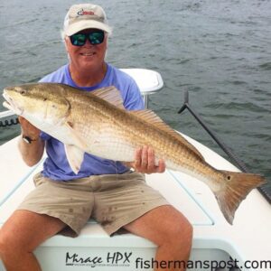 Henry Beckham with a red drum that struck a live finger mullet at the Little River jetties while he was fishing with Hackney Parker on the "Superfly."