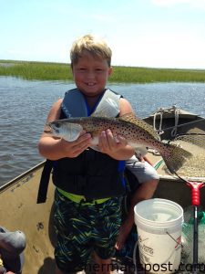 Bryson Mayo with his first speckled trout, an 18" fish that inhaled a live bait on a Carolina rig near Carolina Beach Inlet.