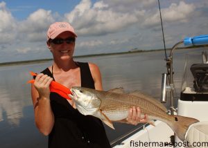 Kathy Bernstein with her first red drum, an upper-slot fish that bit a live shrimp under a Bomber Paradise Popper in a Morehead-area marsh.