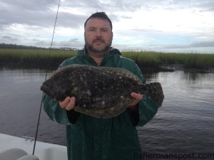 Jason Long, of Currie, NC, with a 3 lb. flounder that struck a live finger mullet in a Bald Head Island Creek.