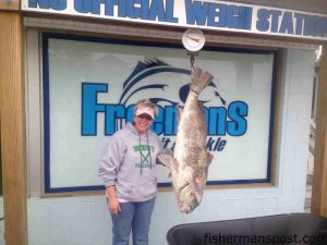 Renee Tilley, of Shallotte, NC, with 81 lb. black drum that she hooked off Oceanana Pier after it struck an artificial bloodworm.