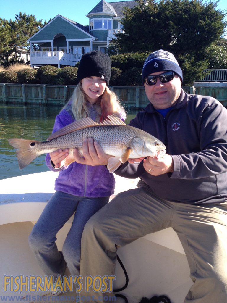 Kate and Philip Maginnes with a slot red drum Kate caught and released under a Wrightsville Beach dock after it bit a peeled shrimp on a Carolina rig.