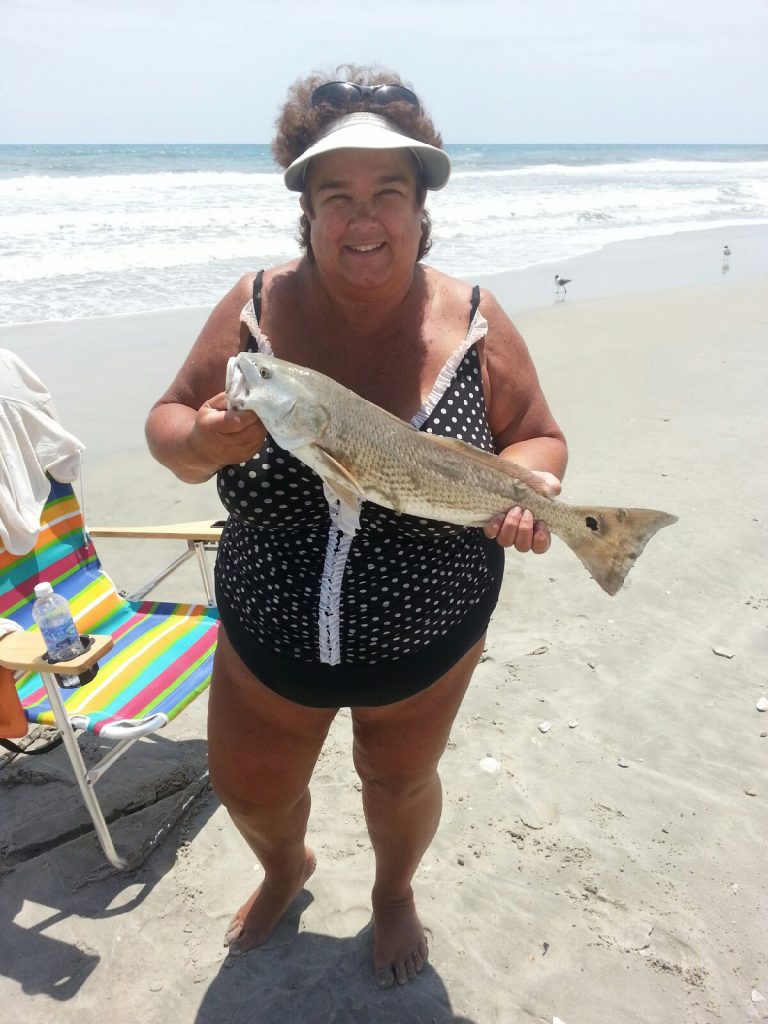 Susan Furr, of Clayton, NC, with a 23" puppy drum that she caught and released in the Indian Beach surf after it struck a piece of shrimp.