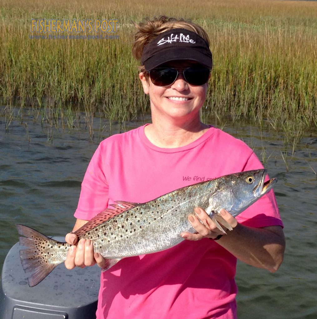 Tia Lee, of Scotts Hill, NC, with her first speckled trout, a 22.5" fish that she hooked in a Wrightsville Beach creek while fishing with her husband.